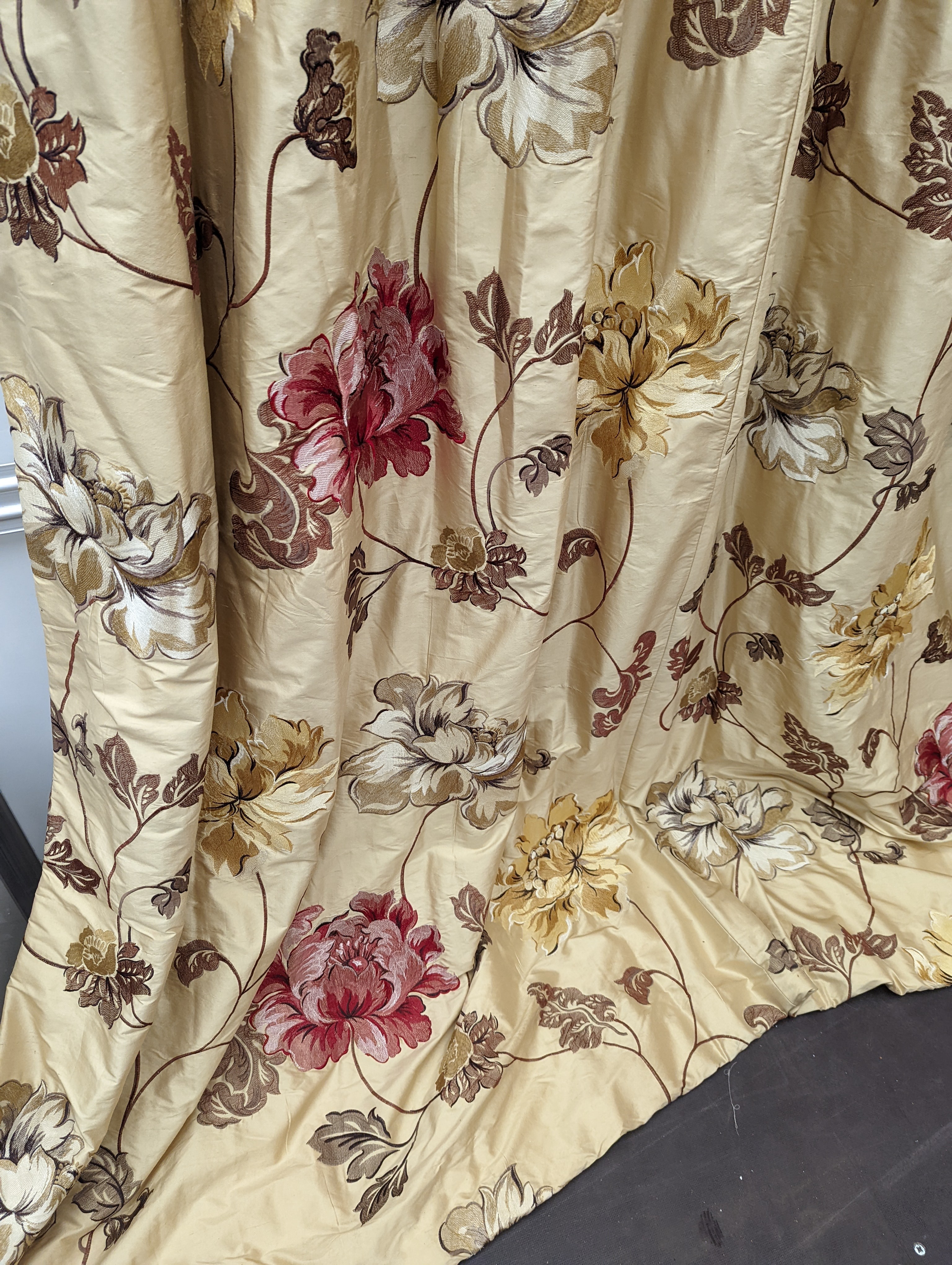 A pair of floral lined curtains. Approximate measurements: Width of top 110cm, Width of bottom 220cm Length 250cm